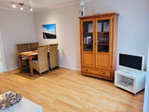 a living room with a wooden table and a television at Strandapartment in Westerland für 2-4 Personen in Westerland (Sylt)