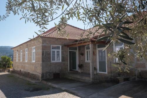 a brick house with white windows and a door at Casa Passal in Marco de Canaveses