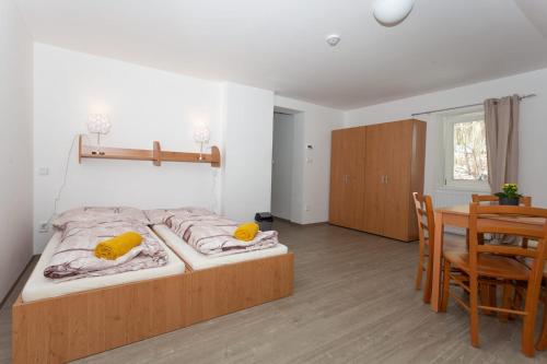 a bedroom with a bed with yellow pillows and a table at Penzion Živec - restaurace a ubytování in Písek