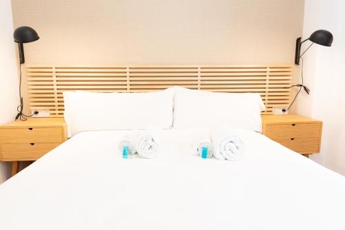 sypialnia z białym łóżkiem z 2 lampami w obiekcie Tourist House Casa Pilatos w Sewilli