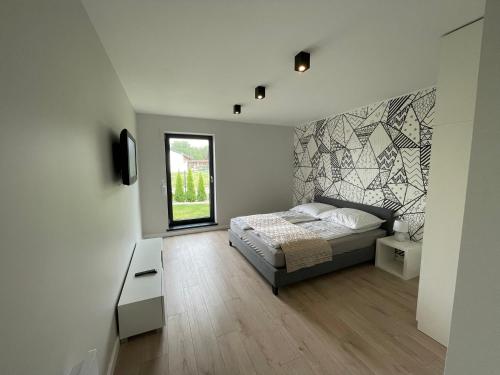 1 dormitorio con 1 cama y una gran pared de mosaico en Dom nad jeziorem obok Uniejowa en Przykona