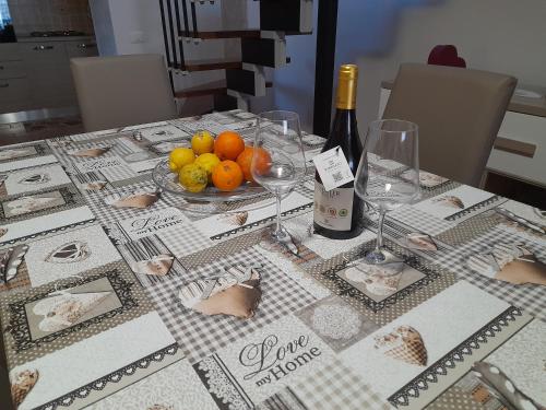 - une table avec une assiette de fruits et une bouteille de vin dans l'établissement La Casa di Sofia, à Piedimonte Etneo