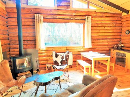 Les FargesMagnifique chalets en rondins avec SPA et Tipis en plaine Nature Environnement ressourçant au calme vue imprenable Lascaux SPA non disponible juillet et aout的小木屋内带壁炉的客厅