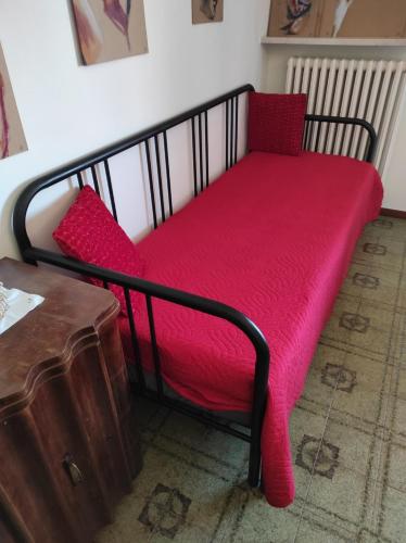 a bed with a red blanket on top of it at La Maison de Mely with garden in Sandra