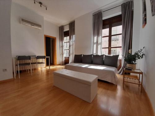 Sala de estar amplia con cama y mesa en Apartamentos Dos Torres Pilar - Balcones con vistas al Pilar, en Zaragoza