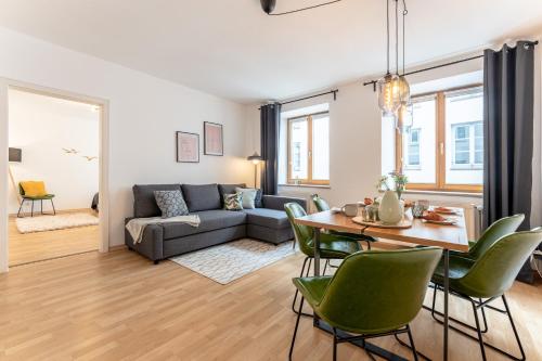 sala de estar con sofá, mesa y sillas en Altstadt Apartments zentral am Rathaus, en Augsburg