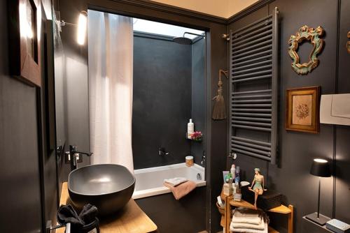 リド・ディ・カマイオーレにあるAppartamento Libeccioのバスルーム(大きな黒いバスタブ、窓付)