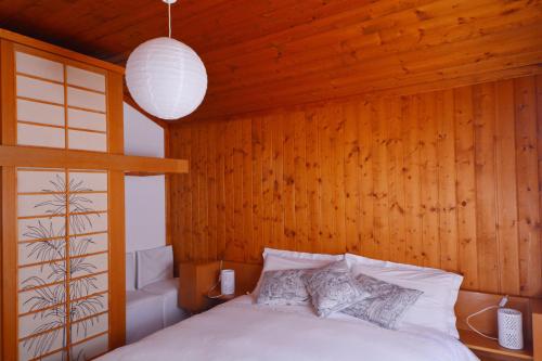 um quarto com uma cama e uma parede de madeira em B&B Claudia em Romeno