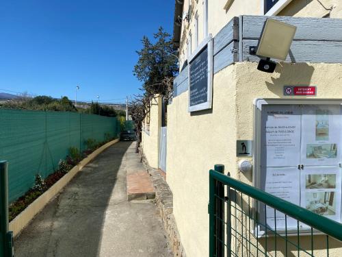 a sign on the side of a building with a fence at Auberge du Chêne in Maureillas