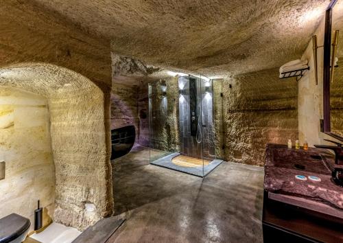 a bathroom with a glass shower in a stone wall at Carus Cappadocia in Goreme