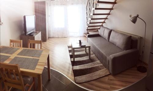 a living room with a couch and a table at Pitypang Apartman in Gyula