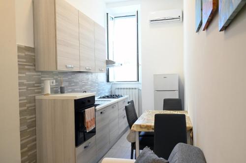 a kitchen with white cabinets and a table with chairs at Home Sweet Home in Civitavecchia