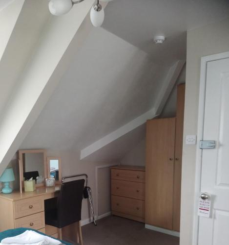 an attic room with a desk and a chair at Cranmore Guest House in Torquay