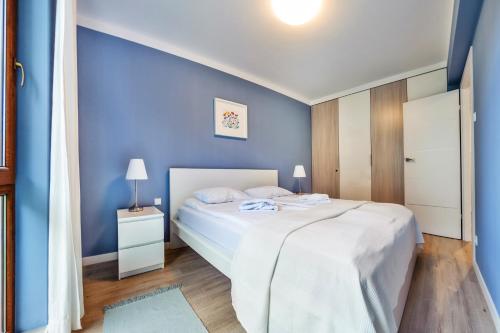 a blue bedroom with a bed and a blue wall at Wczasowa, Sun & Snow in Ustka