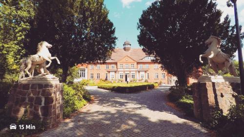 a building with two statues of horses in front of it at Ferienhaus SeeWaldMeer am Pinnower See bei Schwerin in Pinnow