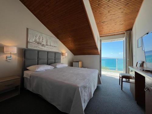 a bedroom with a bed with a view of the ocean at Villa Pitomcia in Podstrana