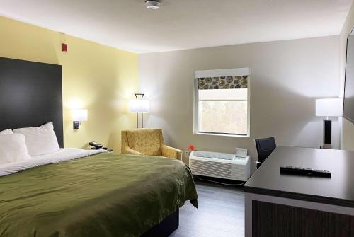 a hotel room with a bed and a desk at Wingate by Wyndham Biloxi - Ocean Springs in Biloxi