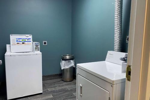 een kleine kamer met een koelkast en een vuilnisbak bij Wingate by Wyndham Biloxi - Ocean Springs in Biloxi