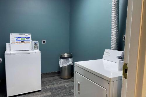 a small room with a refrigerator and a trash can at Wingate by Wyndham Biloxi - Ocean Springs in Biloxi