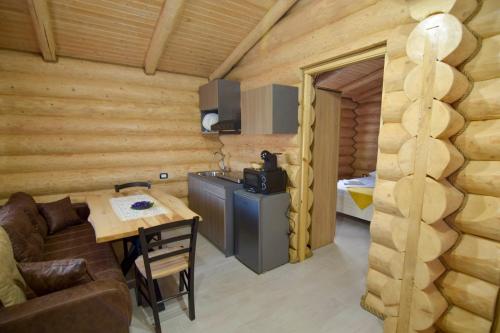 una sala de estar con una mesa en una cabaña de madera en Cabanele Petran en Borşa