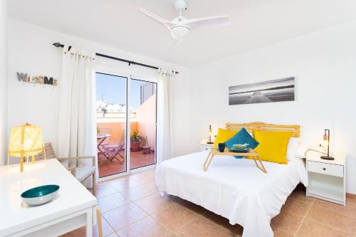 - une chambre blanche avec un lit et un balcon dans l'établissement Home2Book Stunning Apartment Candelaria, Terrace, à Candelaria