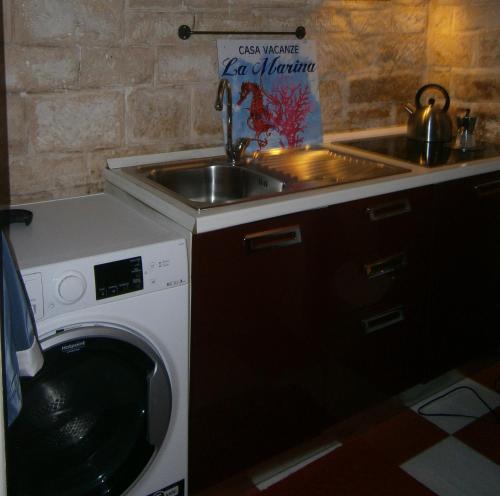 a kitchen with a sink and a washing machine at Appartamento vacanze La Marina in Giovinazzo