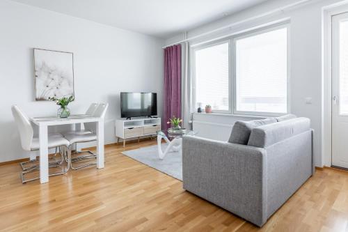 een woonkamer met een bank en een tafel bij Arctic Aurora City Suite in Rovaniemi