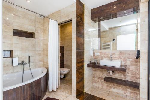 a bathroom with a tub and a sink and a toilet at Hotel Dobczyce in Dobczyce