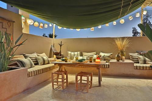 a patio with a couch and a table and chairs at Riad Anyssates in Marrakech
