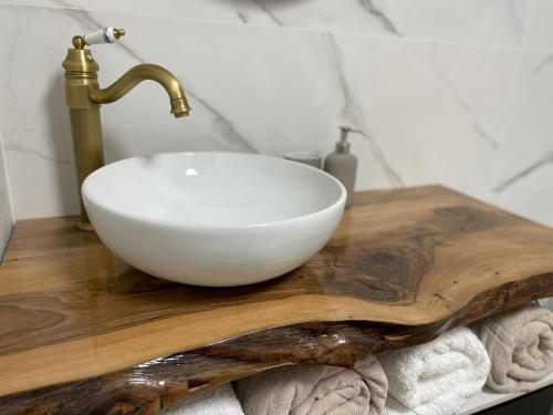 un lavandino da bagno con ciotola bianca su un tagliere di legno di Apartamento Dakota a Sant Carles de la Ràpita