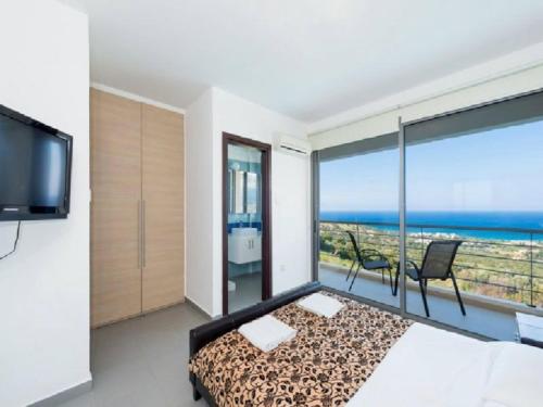 a bedroom with a bed and a view of the ocean at Villa Calypso in Polis Chrysochous