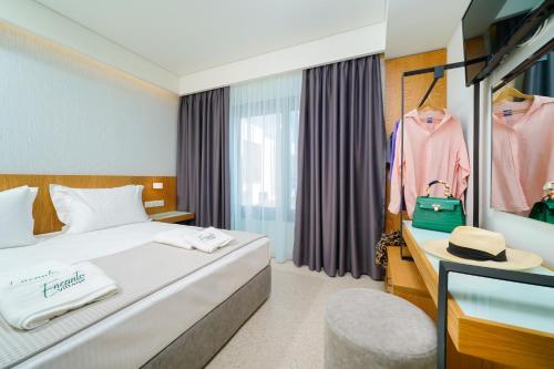 a hotel room with a bed and a desk and a window at Encanto Village -Apartments in Potos