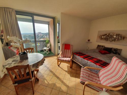 une chambre avec un lit, une table et des chaises dans l'établissement La vue du château - tout confort, à Gréoux-les-Bains