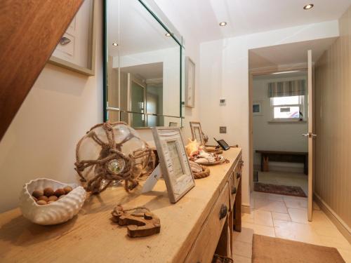 um quarto com uma mesa de madeira e um espelho grande em The Salmon Bothy em Peterhead
