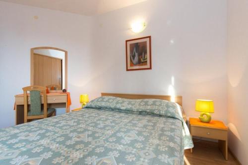 a bedroom with a bed and a desk and a mirror at Marija F2 Apartment in Krk