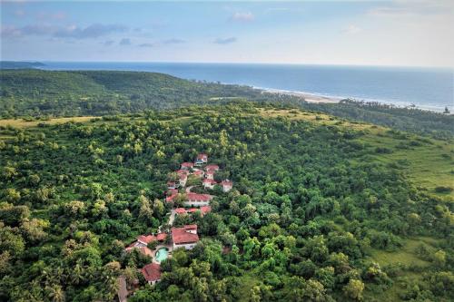 an aerial view of a house on a hill next to the ocean at Amritara Aura Resort & Spa in Mandrem