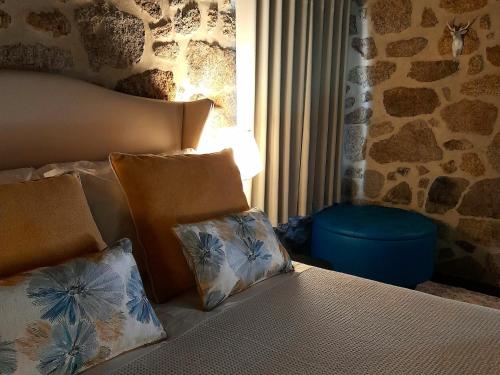 ein Bett mit zwei Kissen darauf in einem Schlafzimmer in der Unterkunft Fragas do Lobo - Casa da Azenha in Castelo Novo