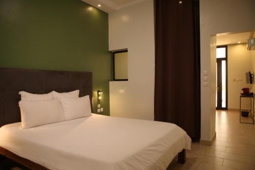 a bedroom with a large bed with white pillows at Au bord de l'eau in Bamako