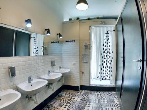 a bathroom with three sinks and a shower at QUO Milano in Milan