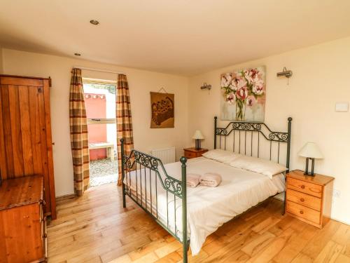 una camera con letto e pavimento in legno di Sutton Cottage a Broadway