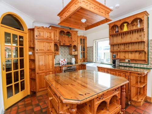 cocina con armarios de madera y mesa de madera en Ballysheen House, en Rosslare