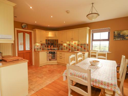 a kitchen with a table and a table and chairs at Fraoch in Waterville