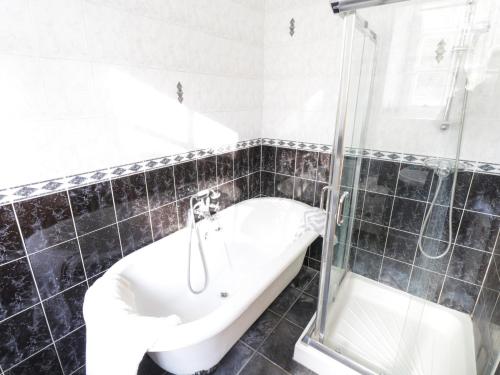 a bathroom with a bath tub and a shower at The Old School House in Carrigallen