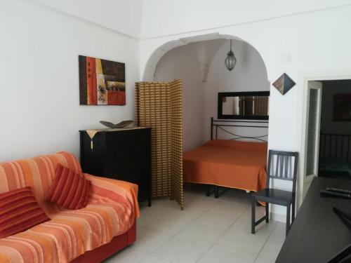 a bedroom with a couch and a bed in a room at Vico Anglani Guest House in Ostuni