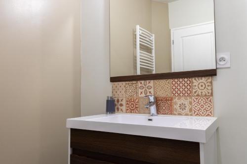 a bathroom with a white sink and a mirror at Le gite du Maréchal in Saint-Aignan