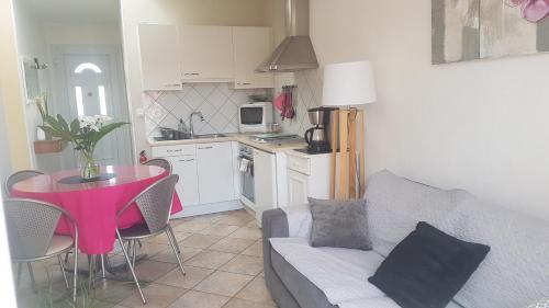 ein Wohnzimmer mit einem Sofa und einem Tisch in der Unterkunft Maison de Line in LʼÎle-dʼOlonne