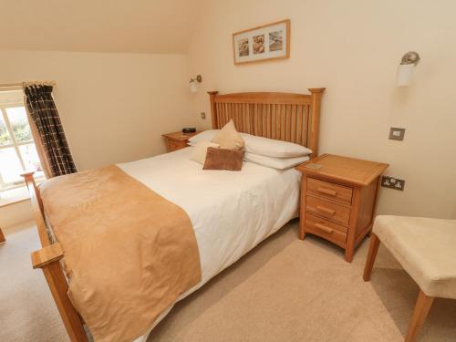 a bedroom with a large bed and a night stand at The Red Barn in Longframlington