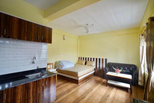 a small room with a bed and a couch at Garden Rest House in Pokhara