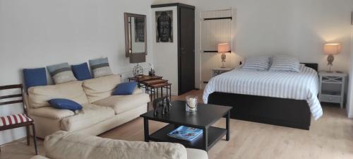 - un salon avec un canapé et un lit dans l'établissement Sur la route des châteaux du Médoc, à Blanquefort
