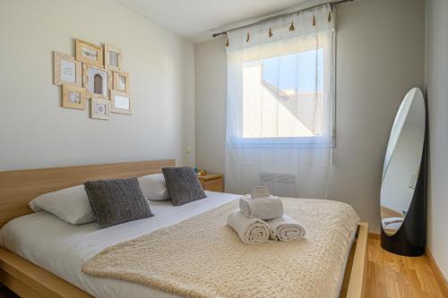 a bedroom with a bed with two towels on it at LE MATISSE - 39m2 dans Vannes avec parking privé in Vannes